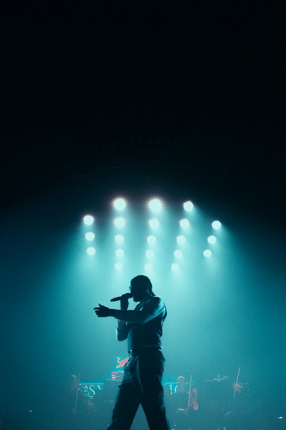 A performer sings into a microphone on a stage.